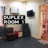 A hotel room with a bed, TV, and bathroom.