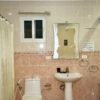 Bathroom with beige tiles and white fixtures.
