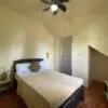 Bedroom with a bed, TV, and ceiling fan.