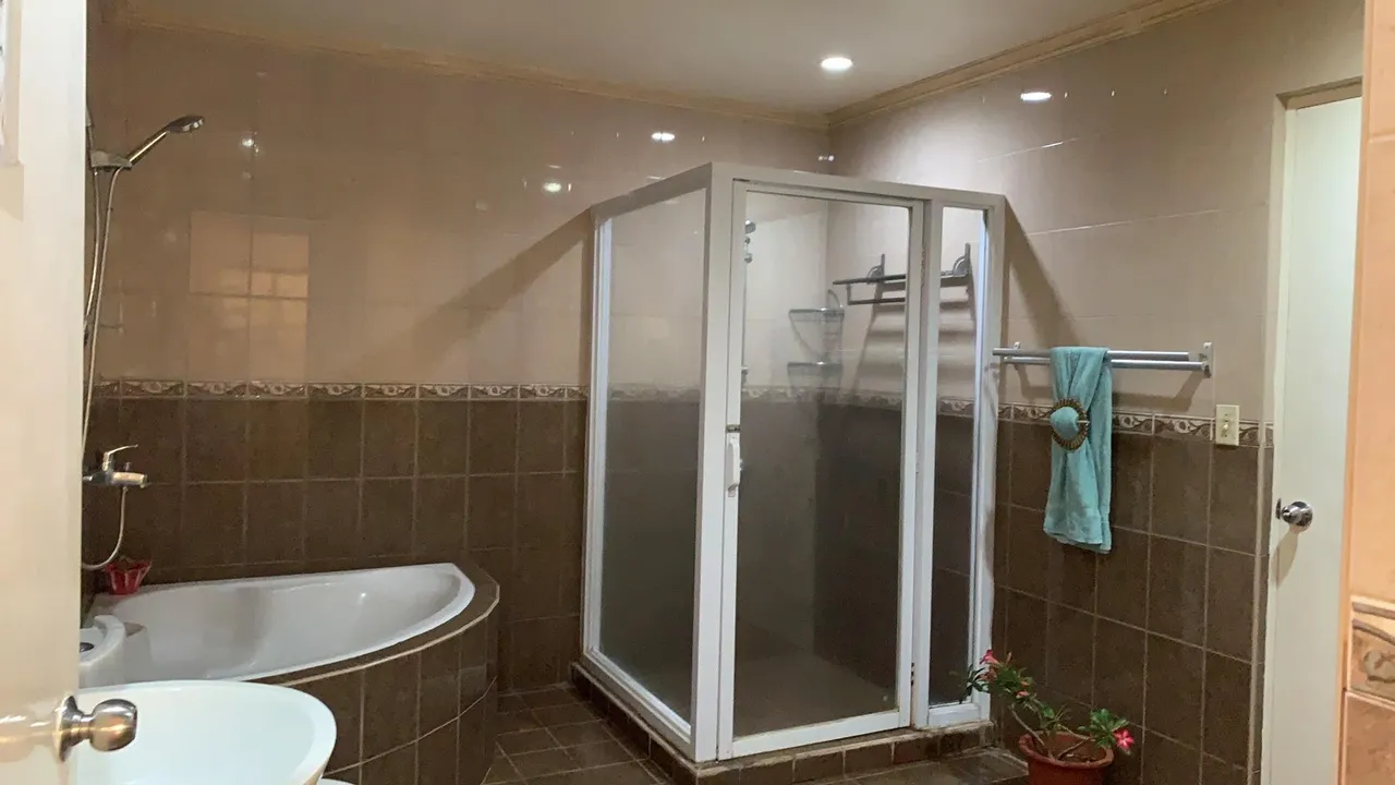 A bathroom with a tub and shower stall.