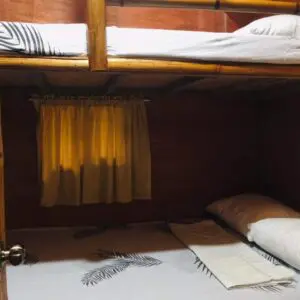 A bunk bed with white pillows and yellow curtains.