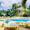 A pool with chairs and umbrellas in the background.