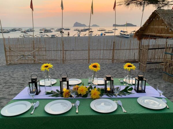 Beachfront dining table set up for a romantic dinner.